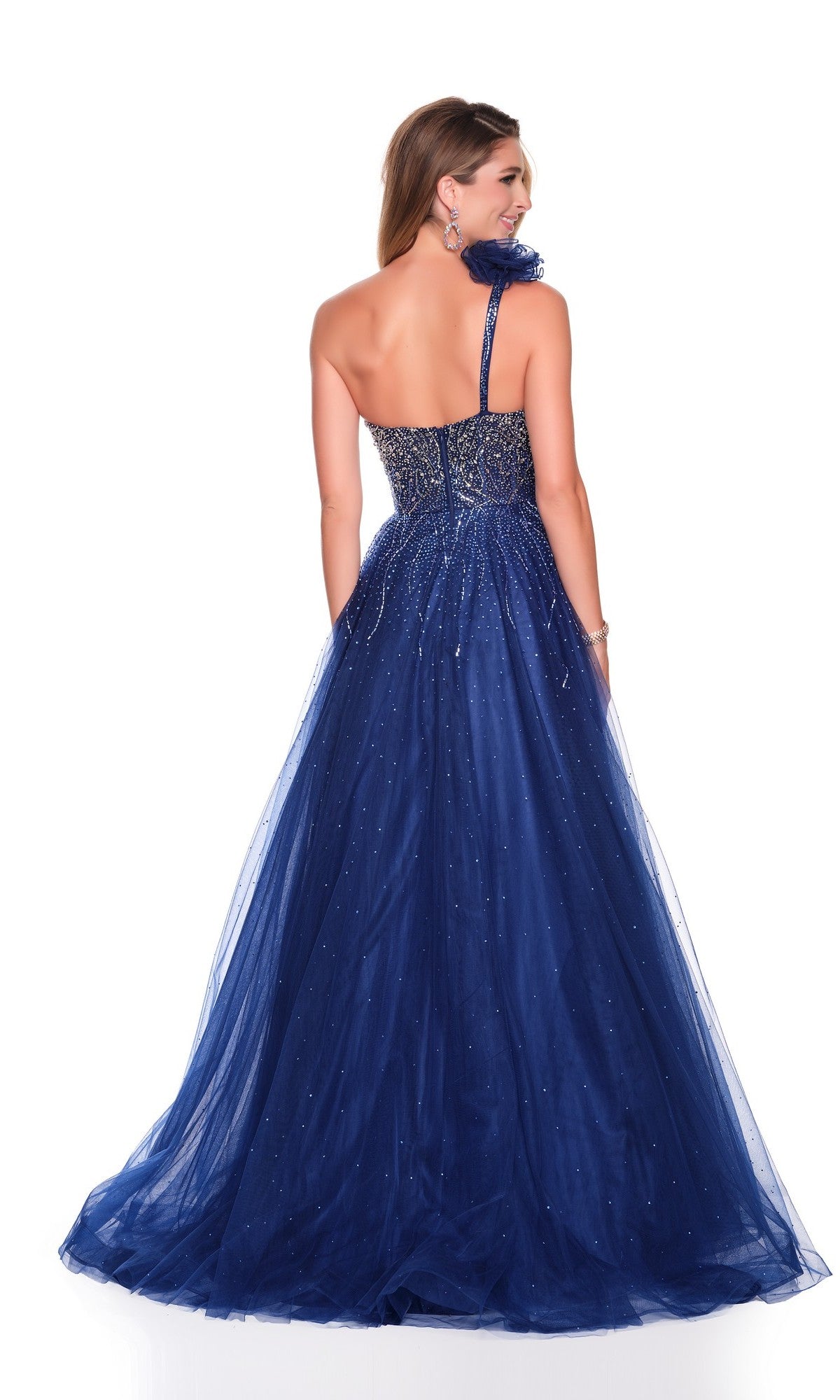 A woman seen from the back wears the Dave and Johnny 12634 long prom dress—a navy blue, one-shoulder gown with sparkling accents and a glitter tulle A-line skirt—posed against a white background.